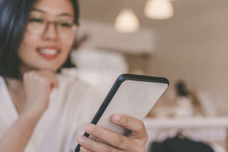 Woman feel happy and smile while using smartphone to do work business, social network, communication in public cafe work space area.の写真素材