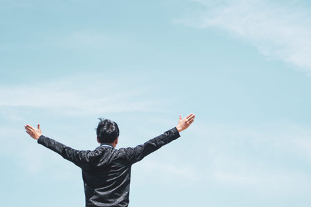 Man rise hands up to sky metaphor freedom concept with sunset sky background.