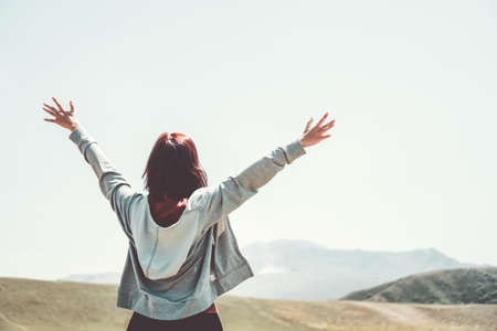 Woman rise hands up to sky freedom concept with blue sky and summer nature landscape of mountain background.の写真素材