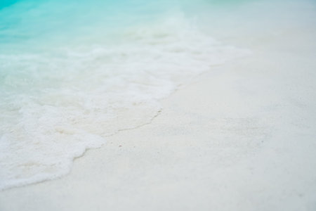 Top view of sand and water clean beach and white sand in summer with sun light blue sky and bokeh abstract  background.の写真素材