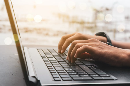 Woman hand using laptop to work study on work desk with clean nature background background....
