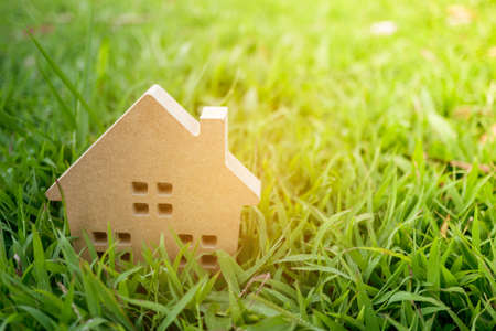 Closed up tiny home model on green grass with sunlight background.の写真素材
