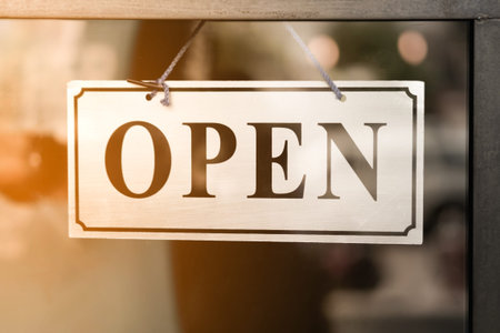 A business sign that says open on cafe or restaurant hang on door at entrance. Vintage color tone...