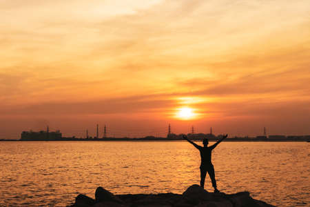 Man rise hands up to sky freedom concept with copyspace sunset sky background.の写真素材