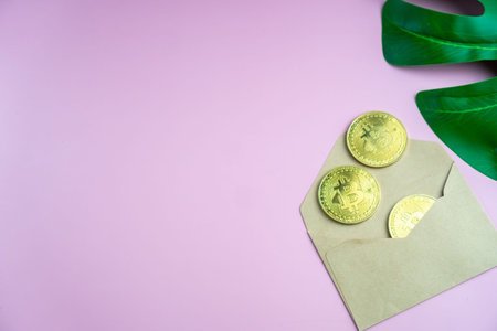 Top view of envelope with golden bitcoin coins as a gift. There are big golden BTC cryptocurrency...
