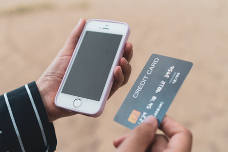 Woman hands holding credit card and using mobile smartphone for online shopping or reporting lost...