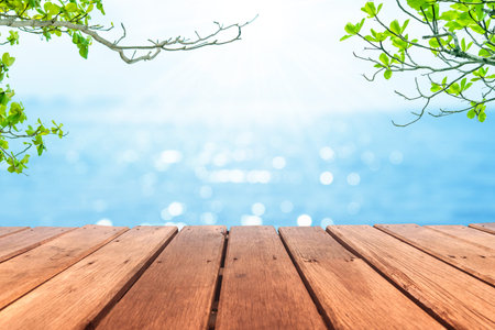 Selective focus of old wood table with blur beautiful beach background for display your product.