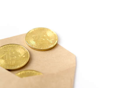 Top view of envelope with golden bitcoin coins as a gift. There are big golden BTC cryptocurrency coins on the table.の写真素材