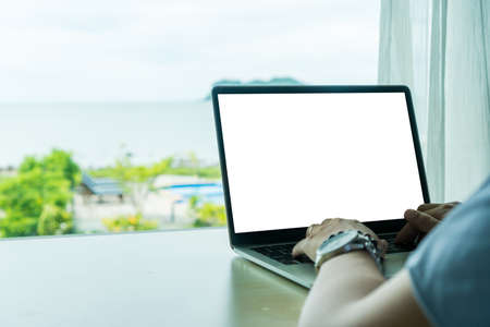 Woman using laptop and smartphone to work study in vacation day at resort room background.の写真素材