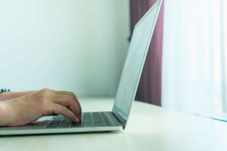 Woman using laptop and smartphone to work study in vacation day at resort room background.の写真素材