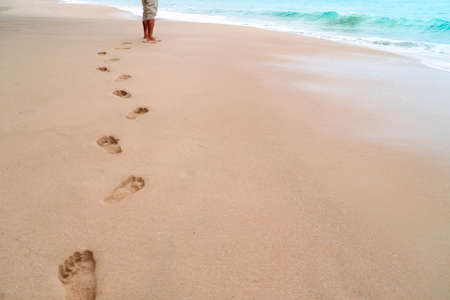 Human footprint on sand summer tropical beach background with copyspace.の写真素材