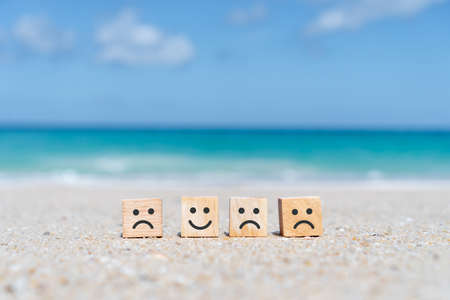 Smile face and cart icon on wood cube. Optimistic person or people feeling inside and service rating when shopping, satisfaction concept in business.の写真素材