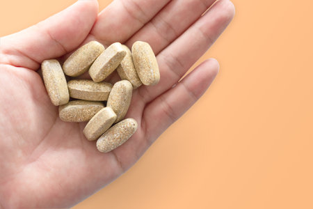 Top view of alternative organic medicine or herbal viatmin supplement capsule tablet on woman hand with copyspace background. Concept of healthy eating lifestyle.の写真素材
