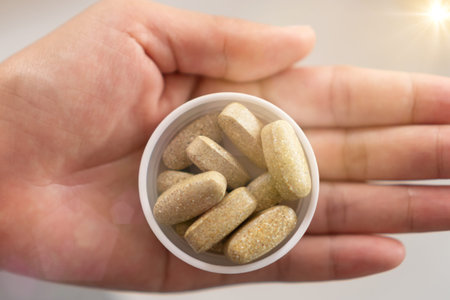 Top view of alternative organic medicine or herbal viatmin supplement capsule tablet on woman hand...