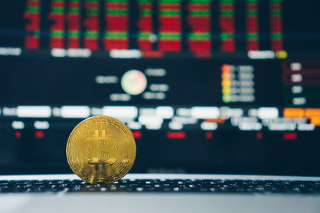 Bitcoin crypto currency digital gold money coin replica on laptop with trading stock financial on...