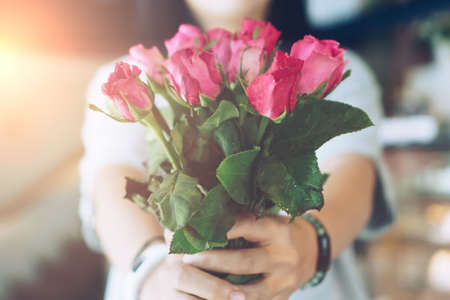 Woman happy hold pink roses recieve from someone in love on Valentine's day.の写真素材
