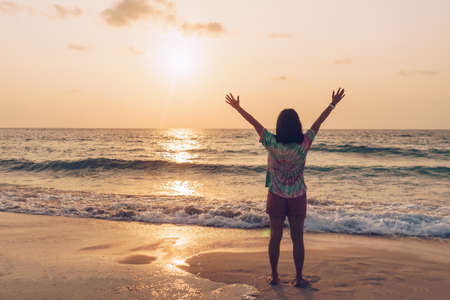 Woman rise hands up to sky travel around the world with summer beach freedom and relax life.の写真素材