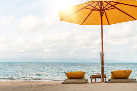 Umbrella and chair at tropical summer beach background with copy space blue sky.の写真素材