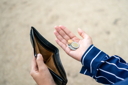Woman holds an empty purse and coins in hand meaning money financial problem or bankrupt jobless, broke after credit card payday jobless, debt concept.の写真素材