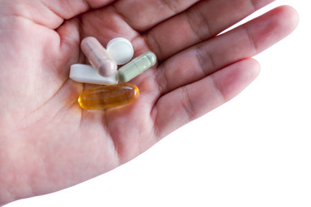 Hand hold medicine or vitamin isolated on white background.の写真素材