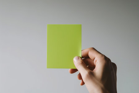 Hand hold color blank paper on white background.の素材