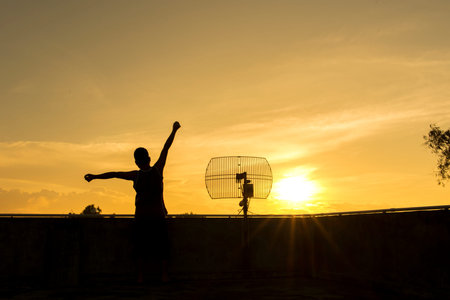 A woman working out gainst the rising sun