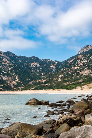 Rotten stones by the sea and stone mountainsの写真素材