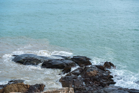 The waves hit the rocks on the shoreの写真素材