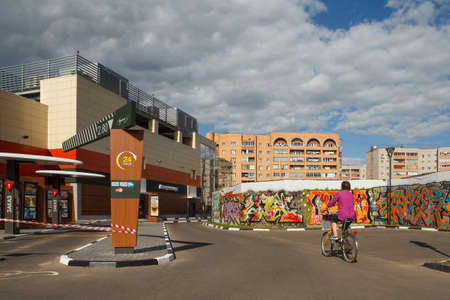 Dubna, Russia - Jul 21, 2014: Daytime street view of the city with a woman riding bike.のeditorial素材