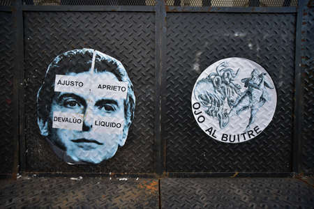 Buenos Aires, Argentina - Nov 19, 2016: Poster of the Argentine President Mauricio Macri with signs in Spanish: 'I Cut' 'I Press' 'I Devaluate' 'I Liquidate' and other sticker 'Attention Vulture'.のeditorial素材