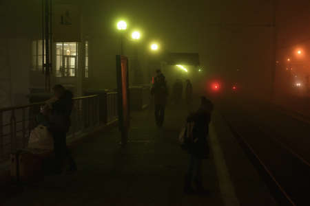 Dubna, Russia - 5 November, 2018: People in Dubna railway station are waiting for commuter train in dense fog at night.のeditorial素材