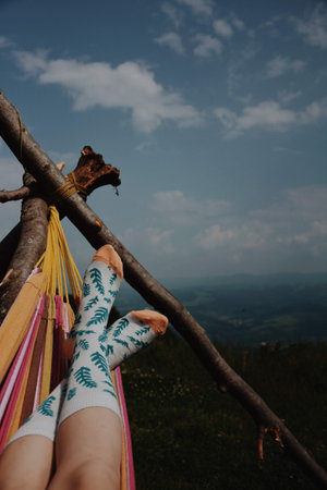 Girl relaxing in a hammock on the top of the mountain.の写真素材