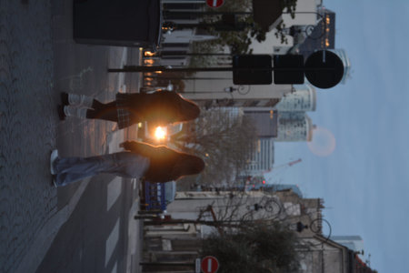 Low angle view of a man using a smartphone while walking in the street