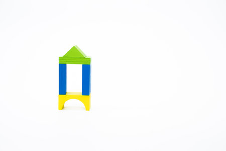 Colorful wooden blocks arranged in a simple house-like shape, isolated on white background, symbolizing creativity and childhood learning.の写真素材