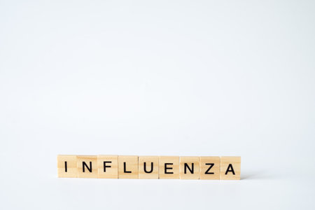 Wooden letter blocks spelling 'INFLUENZA' neatly arranged on a plain white background, representing medical and health concepts in a minimalist styleの写真素材