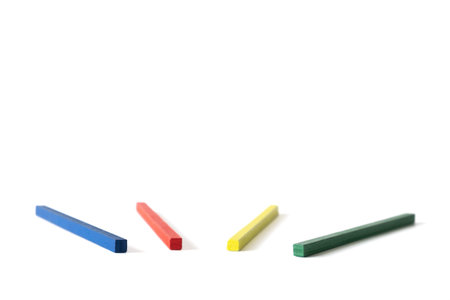 Four colored wooden sticksâ€”blue, red, yellow, and greenâ€”neatly spaced on a clean white...