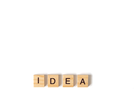 Four wooden blocks spelling the word 'IDEA' arranged on a clean white background, representing minimalist creativity, inspiration, and conceptual thinking.の写真素材