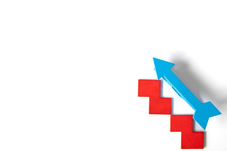 A blue arrow placed diagonally on top of three red stair-shaped blocks against a white background,...