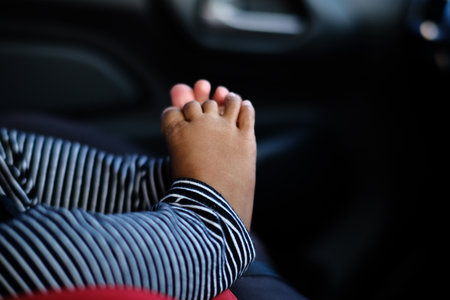 Close-up, high-detail shot of a newborn baby's small foot and toes wearing striped clothing. Symbol of new life and innocence.の写真素材