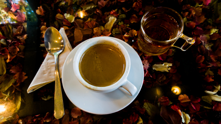 Coffee and tea in cafe with sunlight on flower tableの写真素材