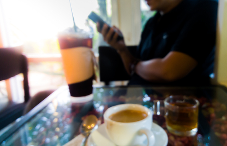 Coffee and tea in cafe with sunlight on flower tableの写真素材
