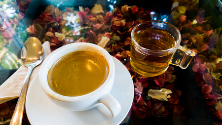 Coffee and tea in cafe with sunlight on flower table.の写真素材