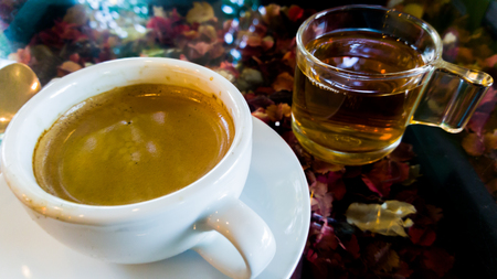 Coffee and tea in cafe with sunlight on flower table.の写真素材