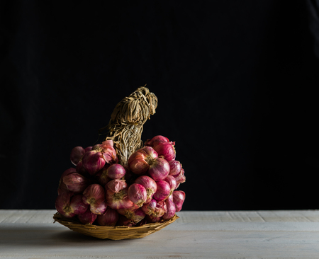shallots still life on white table with black background, onion bulb season herb vegetableの写真素材