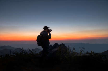 Silhouette of a photographer with his camera on a hilltop, chiangrai province, thailandの写真素材