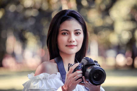 One women in Public park drink coffee and read a book relaxed at bangkok city thailandの写真素材