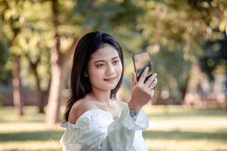 One women in Public park drink coffee and read a book relaxed at bangkok city thailandの写真素材