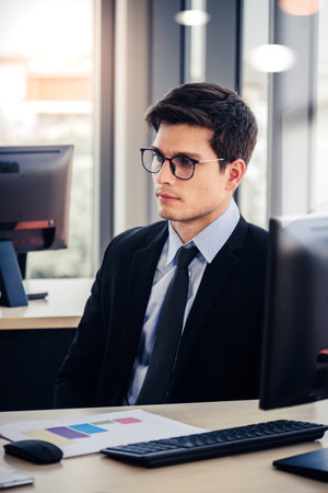 People working on laptop at their desk with manager supervising the work. Business people working in a small office.の写真素材