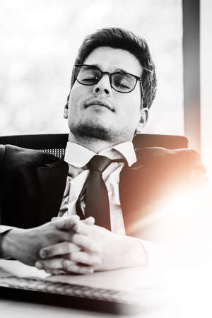 Black and white design man and women working on laptop at their desk with manager supervising the work. Business people working in a small office.の写真素材