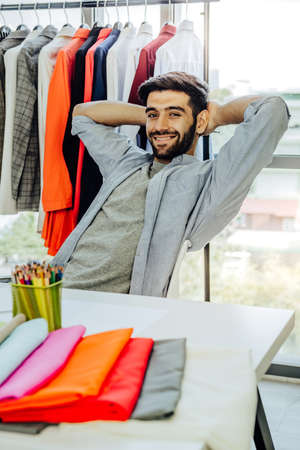 Creative Garment Design Tailoring Service Concept. Cute Professional Sewer Measuring Male Bearded Model Waist or Hip. Smiling Outfit Designer Taking Man Measurement for Formal Suit with Tape Meterの写真素材
